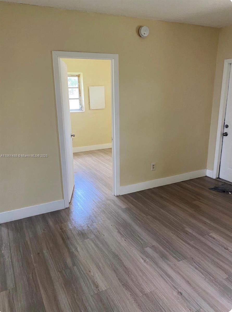 1111 Southwest 2nd Street, Unit 1111 Homestead, FL 33030 - Photo 6 of 15 an empty room with wooden floor and windows
