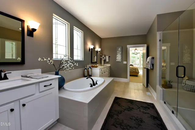a spacious bathroom with a double vanity sink a mirror and a shower
