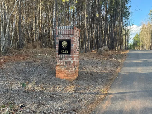a view of a street with a bench and trees