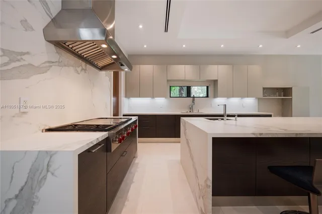 a kitchen with stainless steel appliances granite countertop a sink a stove and a refrigerator