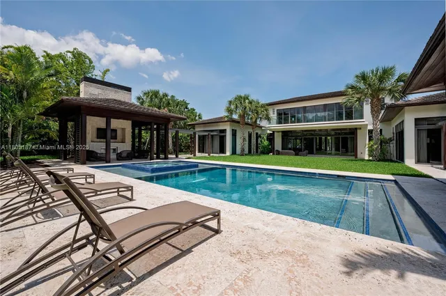 a view of swimming pool with lawn chairs and plants