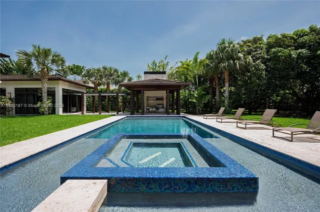 a view of swimming pool with chairs and yard