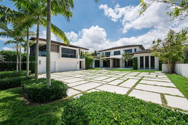 a front view of a house with a yard and potted plants