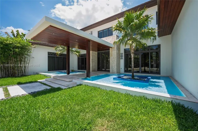a view of a house with a patio and a yard