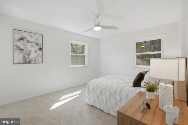a bedroom with a bed and a lamp on dresser