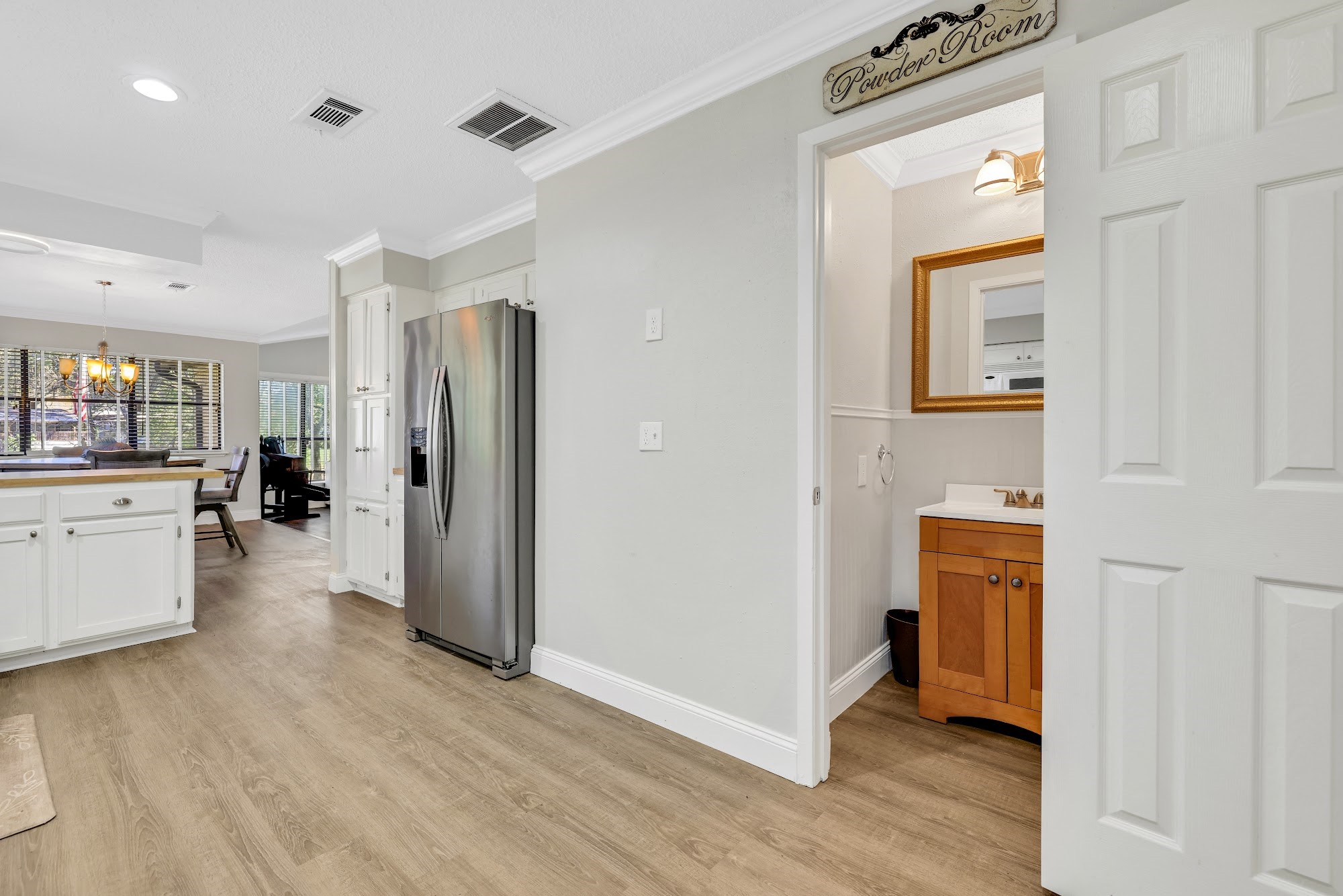 148 South Oak Bluff Street Trinity, TX 75862 - Photo 19 of 46 a view of a hallway with wooden floor windows and a kitchen