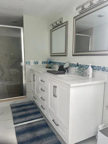 a bathroom with double sink and a mirror