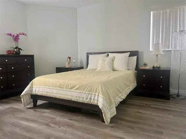 a large bed sitting in a bedroom next to a cabinet and a potted plant