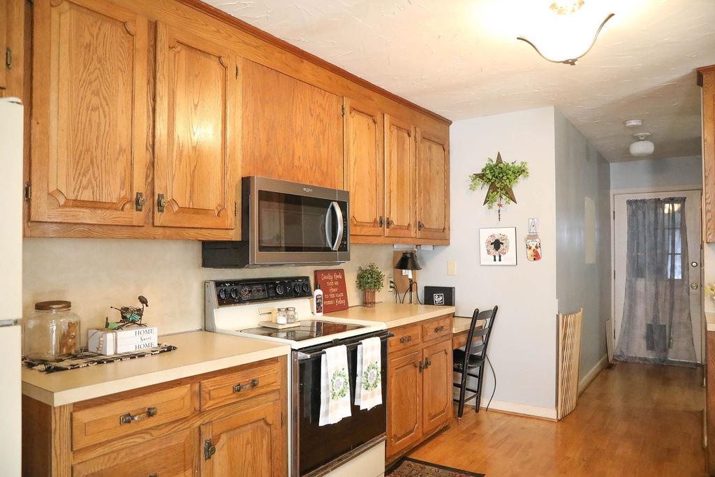 1401 Ladd Road Waynesboro, VA 22980 - Photo 17 of 53 a kitchen with stainless steel appliances granite countertop a stove a sink dishwasher and microwave with wooden floor