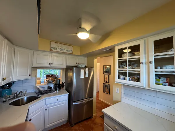 a kitchen with stainless steel appliances granite countertop a refrigerator a sink a stove and a microwave oven