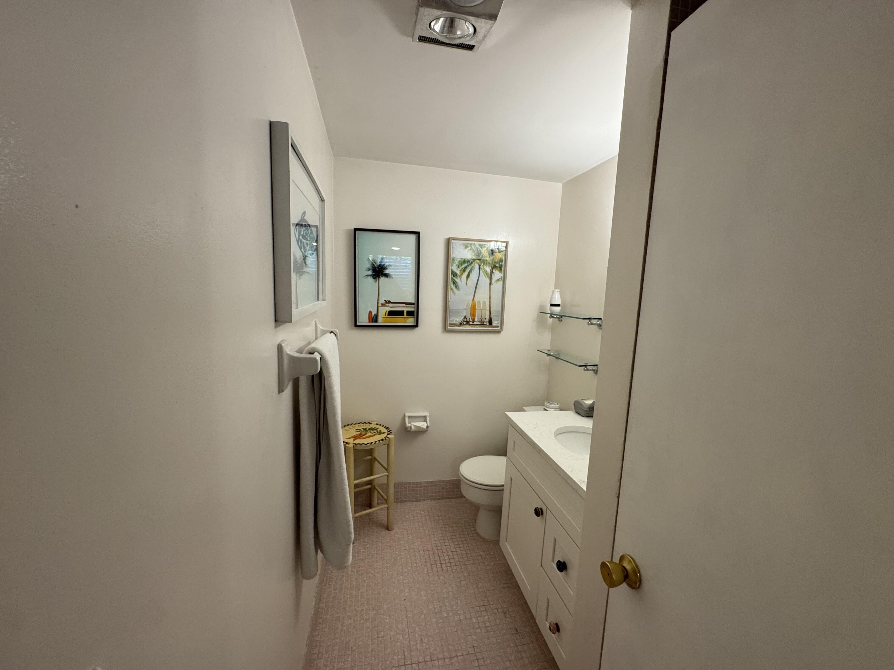 5505 North Ocean Boulevard, Unit 12103 Ocean Ridge, FL 33435 - Photo 19 of 28 a bathroom with a toilet sink and mirror