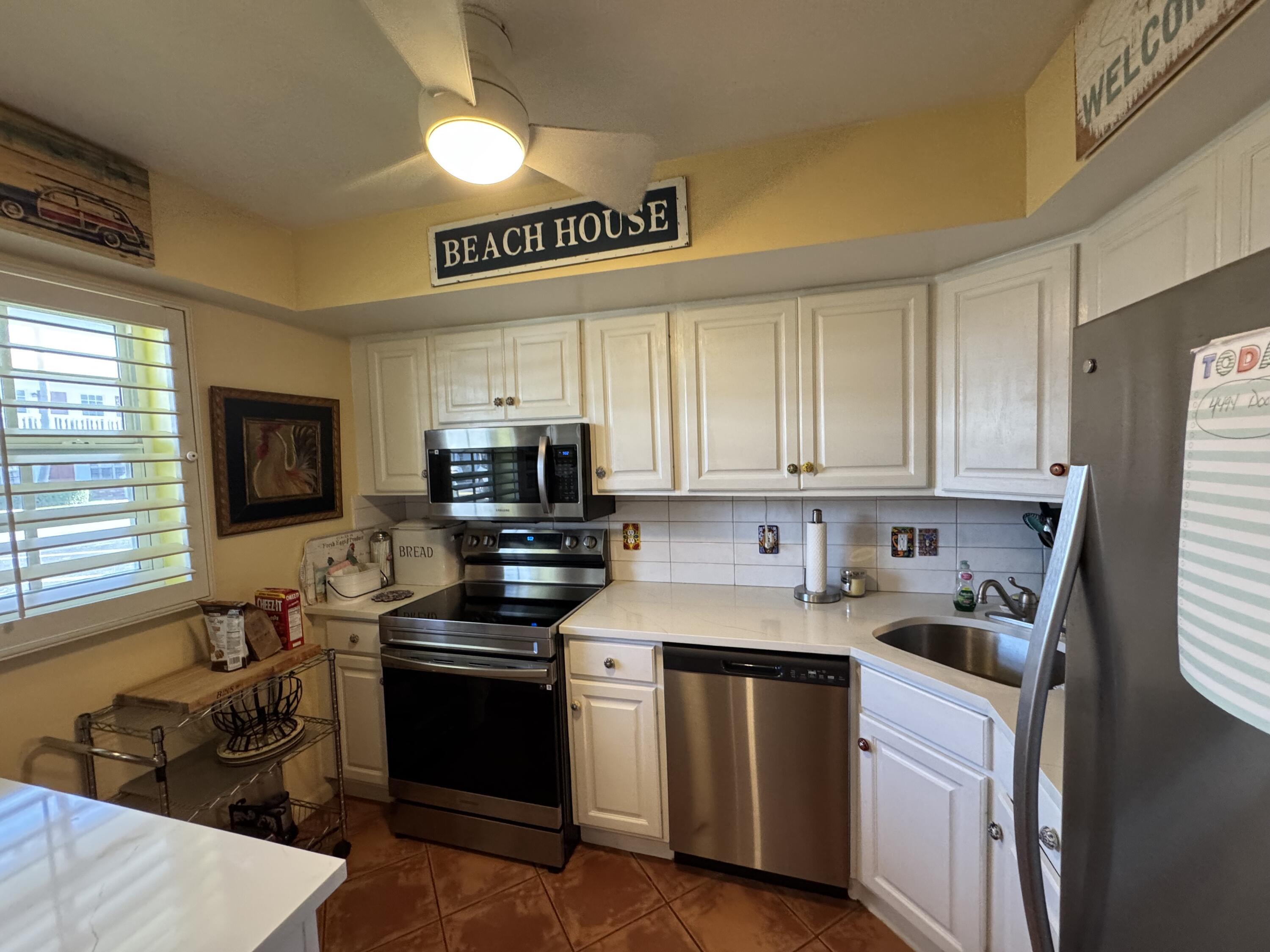 5505 North Ocean Boulevard, Unit 12103 Ocean Ridge, FL 33435 - Photo 2 of 28 a kitchen with stainless steel appliances granite countertop a sink stove microwave and refrigerator