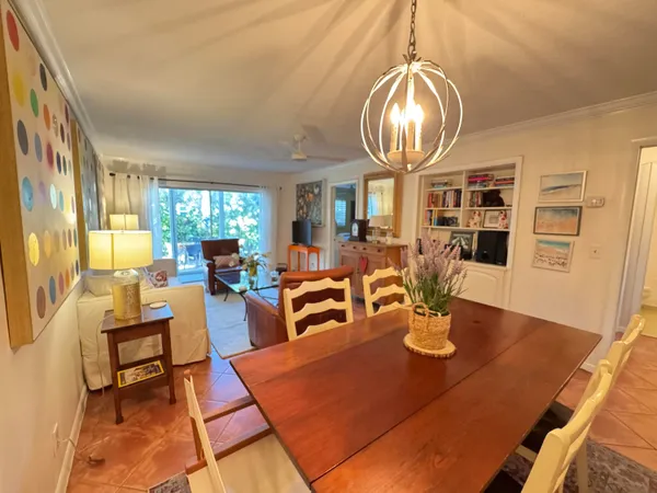 a dining room with wooden floor a chandelier a wooden table and chairs