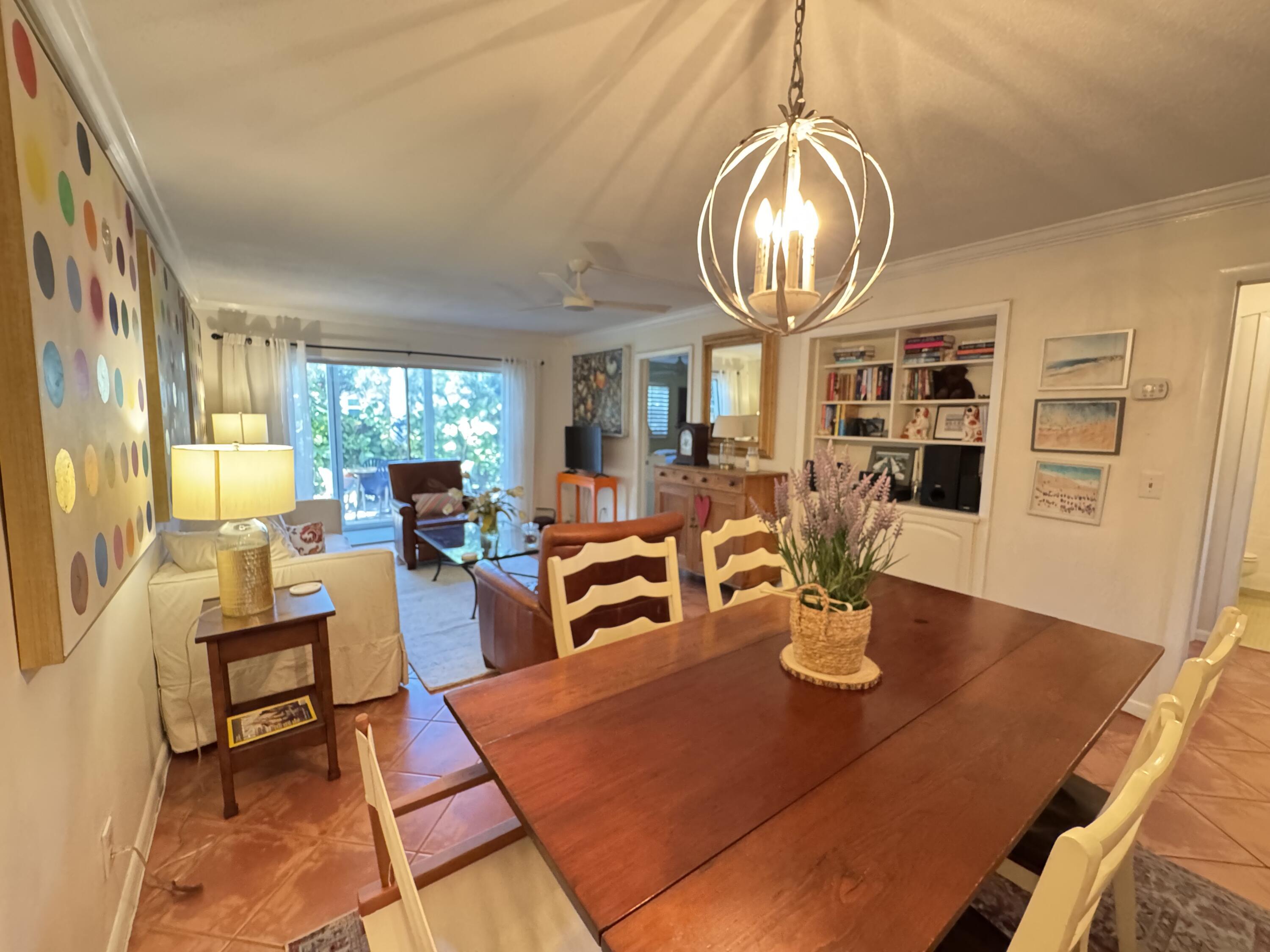 5505 North Ocean Boulevard, Unit 12103 Ocean Ridge, FL 33435 - Photo 6 of 28 a dining room with wooden floor a chandelier a wooden table and chairs