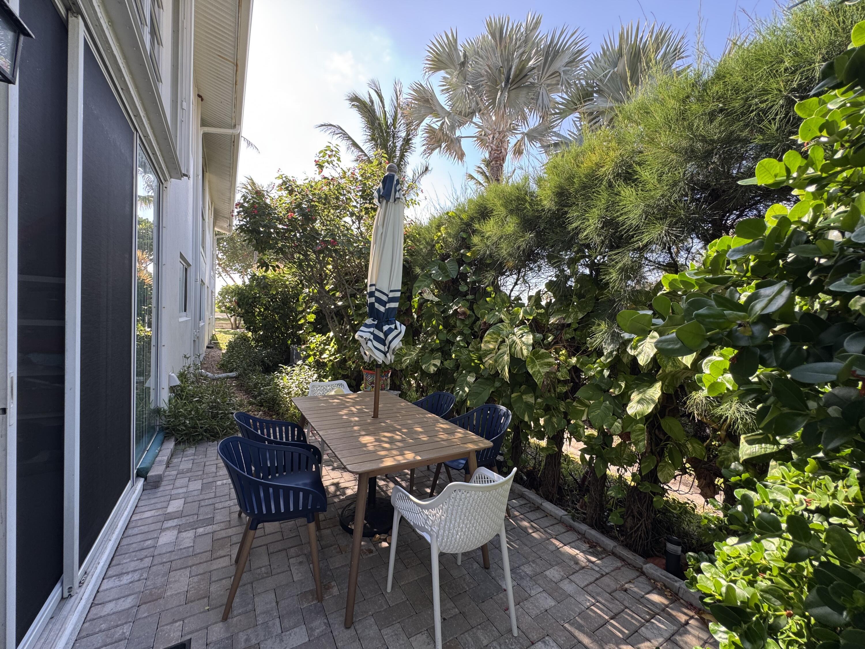 5505 North Ocean Boulevard, Unit 12103 Ocean Ridge, FL 33435 - Photo 8 of 28 a backyard of a house with table and chairs