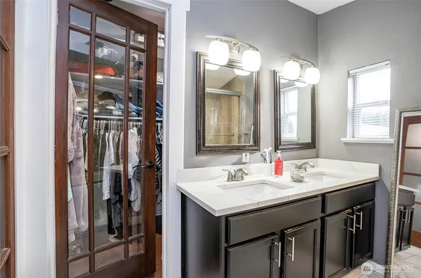 a bathroom with a double vanity sink and a mirror