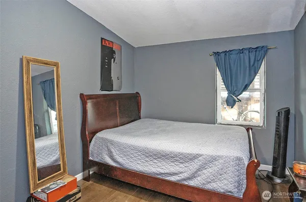a bedroom with a bed and wooden floor