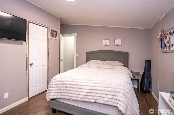 a bedroom with a bed and a flat screen tv