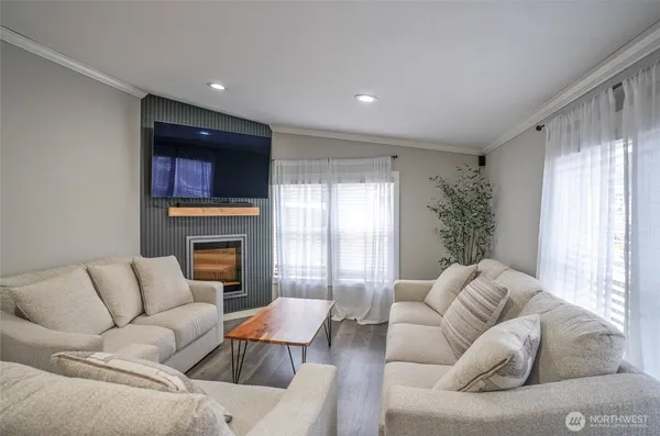 a living room with furniture fireplace and a large window