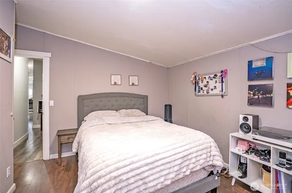 a bedroom with a bed and wooden floor