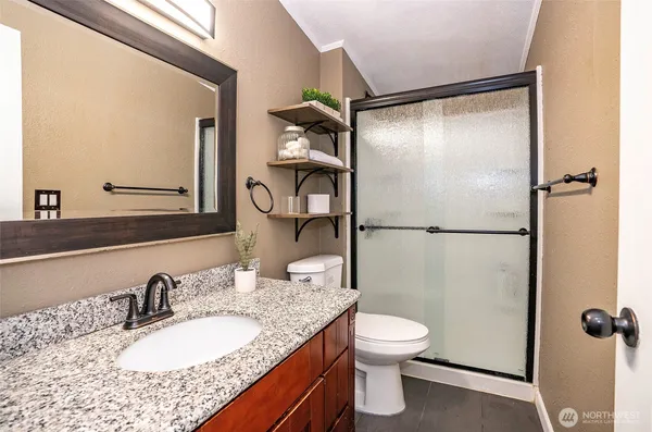 a bathroom with a granite countertop sink toilet and shower