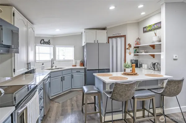 a kitchen with granite countertop stainless steel appliances a sink stove and refrigerator