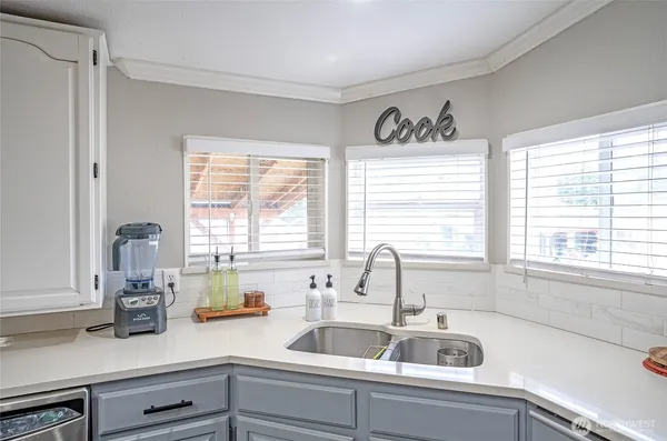 a kitchen with sink a window and cabinets