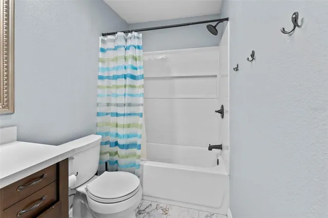 a bathroom with a bathtub shower sink mirror vanity and toilet