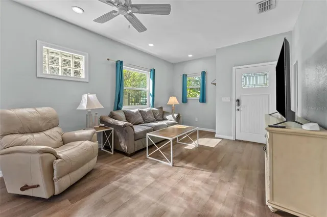 a living room with furniture a large window and a flat screen tv
