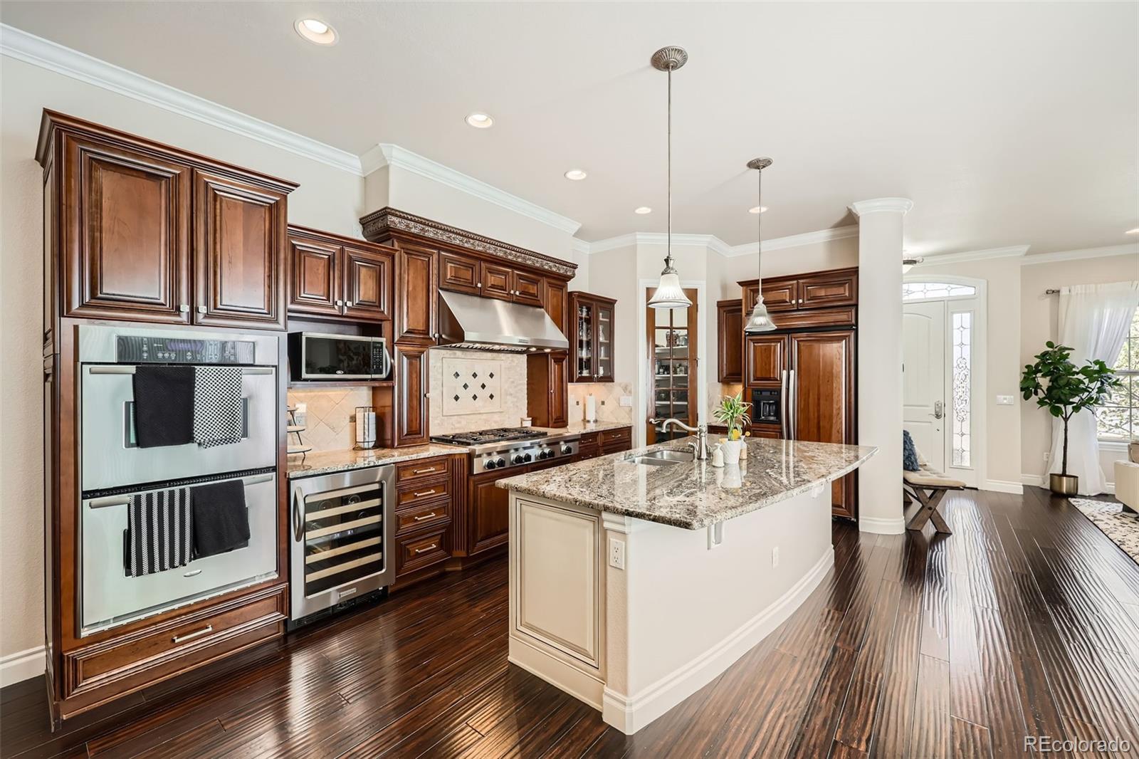 9182 Ridgegate Parkway Lone Tree, CO 80124 - Photo 11 of 31 a kitchen with stainless steel appliances granite countertop a sink a stove and a wooden floors