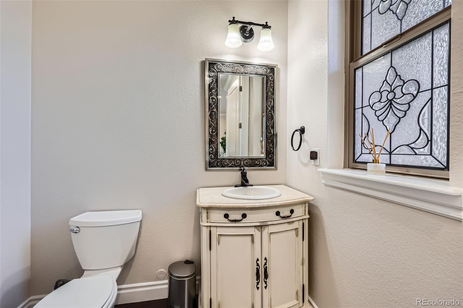 9182 Ridgegate Parkway Lone Tree, CO 80124 - Photo 12 of 31 a bathroom with a toilet a sink and mirror