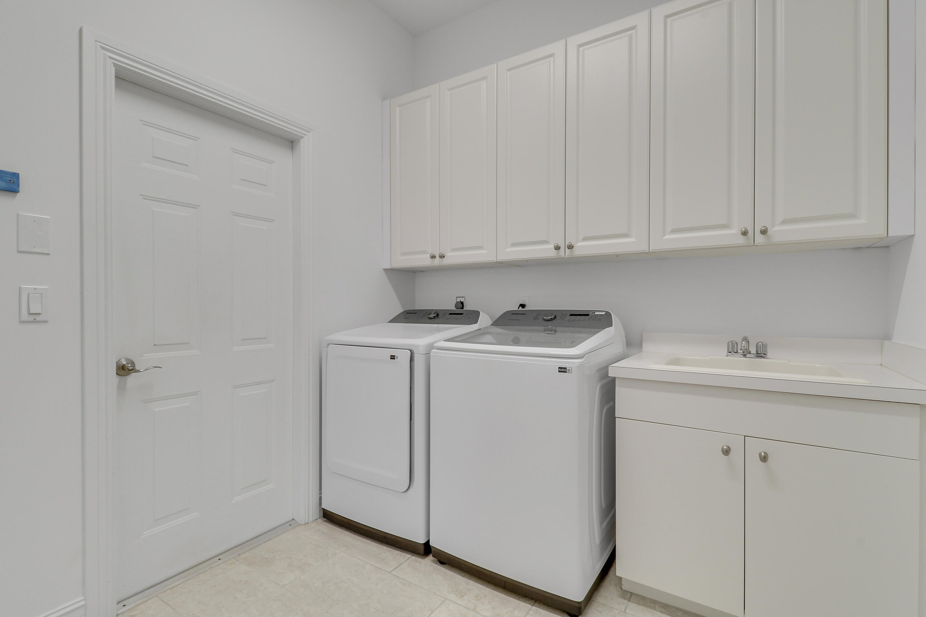 8415 Southeast Governors Way Hobe Sound, FL 33455 - Photo 31 of 105 a utility room with white cabinets washer and dryer