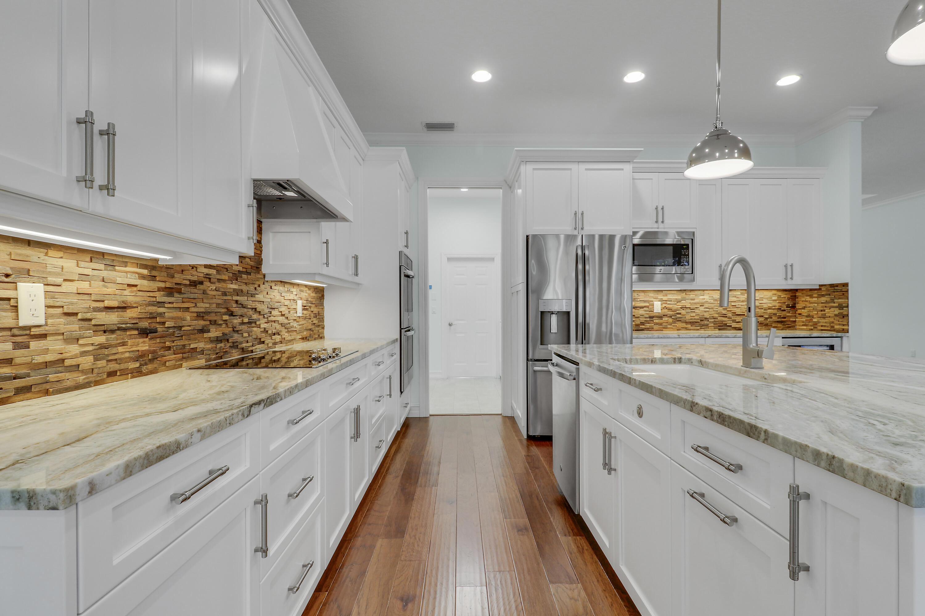 8415 Southeast Governors Way Hobe Sound, FL 33455 - Photo 64 of 105 a large kitchen with kitchen island a large counter top space a sink stainless steel appliances and cabinets