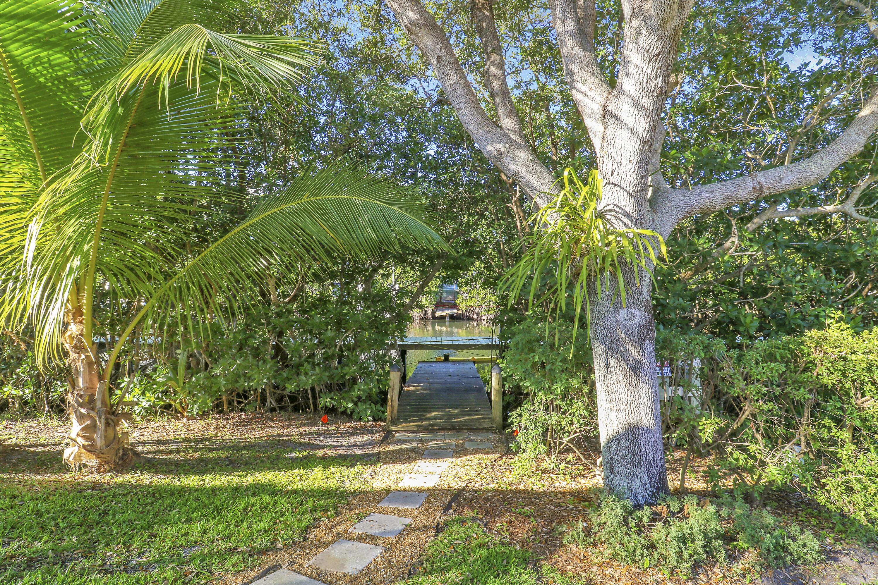 8415 Southeast Governors Way Hobe Sound, FL 33455 - Photo 77 of 105 a front view of a house with a yard and large tree