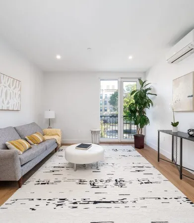 a living room with a couch and a potted plant