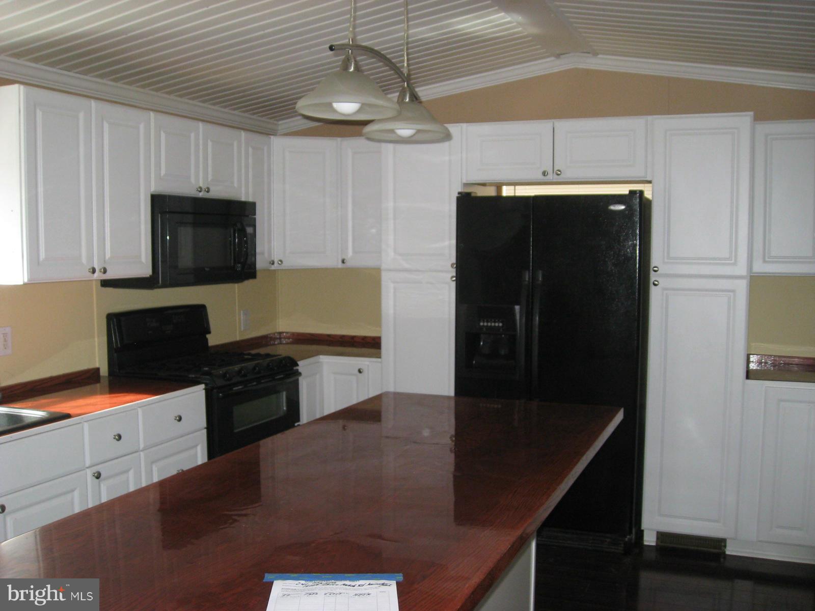 18109 Three Notch Road Lexington Park, MD 20653 - Photo 3 of 6 a kitchen with stainless steel appliances granite countertop a refrigerator a sink and a stove