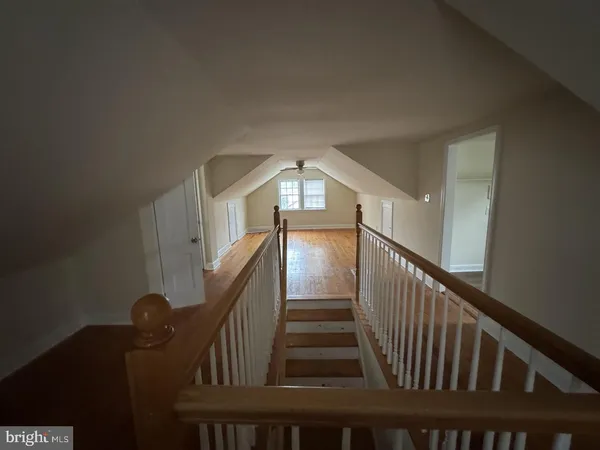 a view of staircase with railing and white walls