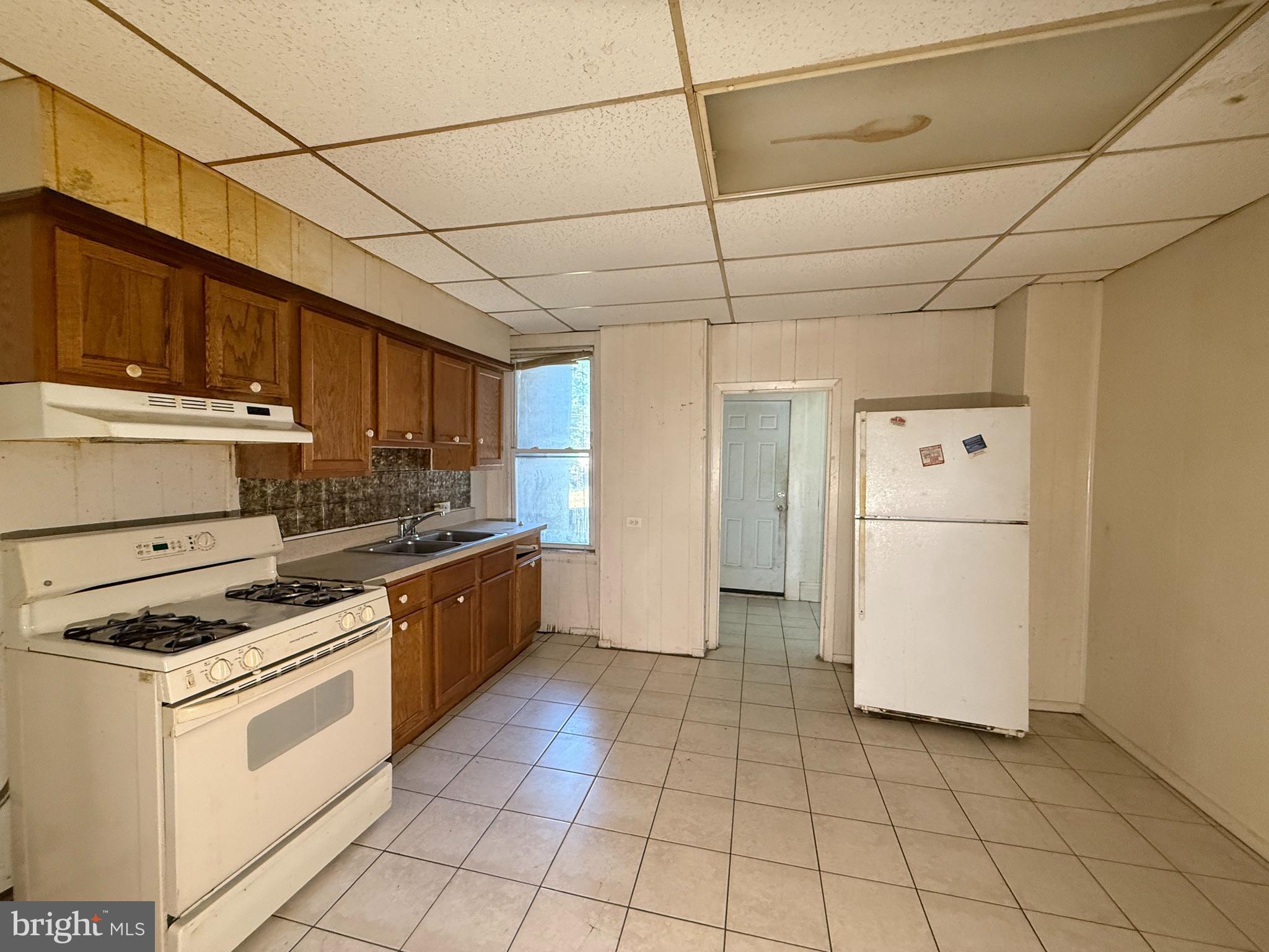 2706 Winchester Street Baltimore, MD 21216 - Photo 4 of 16 a kitchen with a stove a refrigerator and cabinets