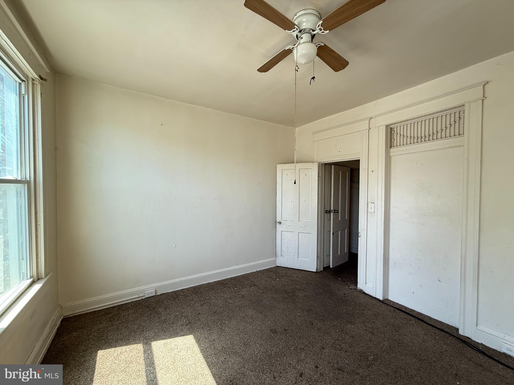 2706 Winchester Street Baltimore, MD 21216 - Photo 5 of 16 an empty room with windows and fan