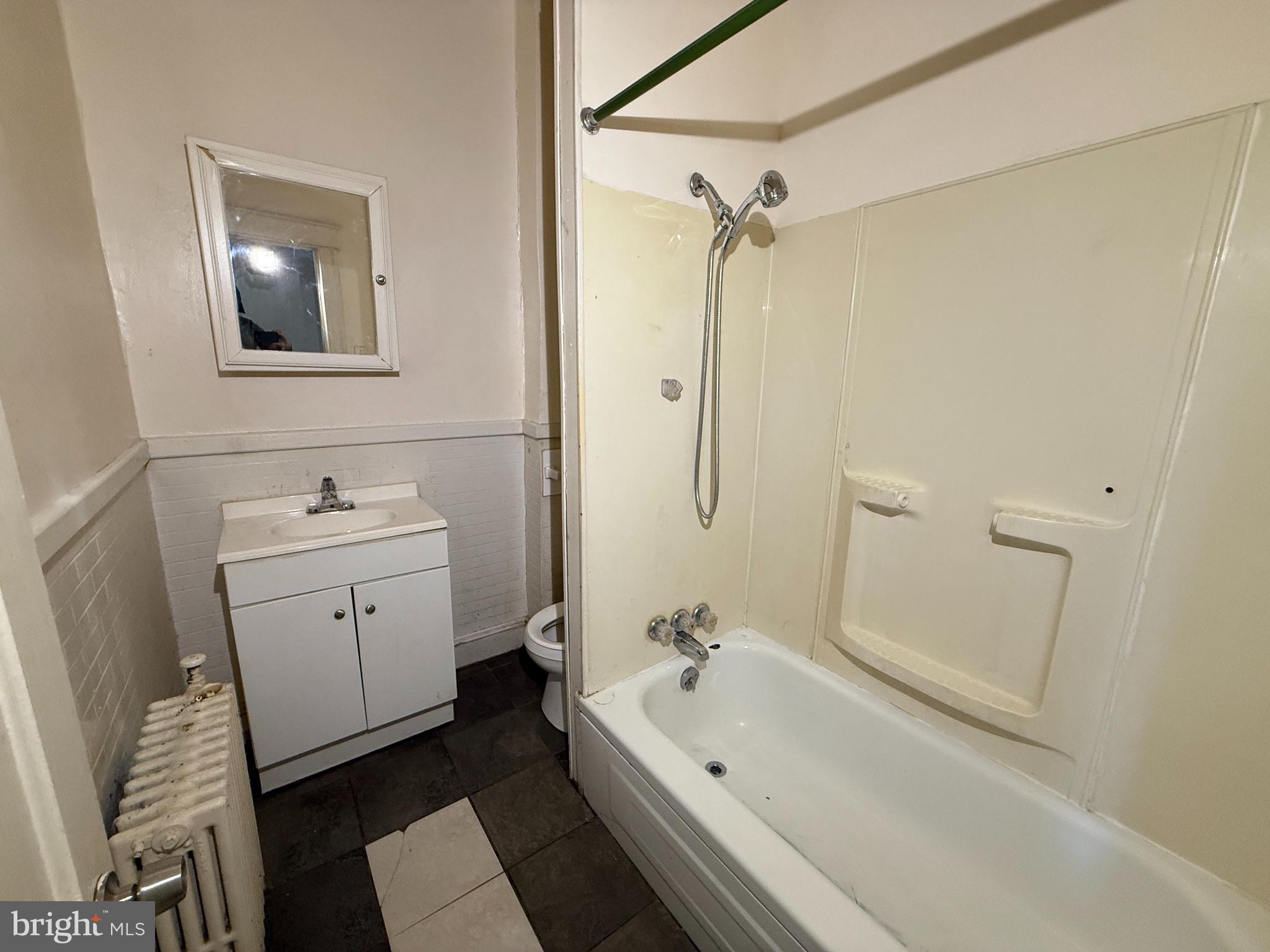 2706 Winchester Street Baltimore, MD 21216 - Photo 10 of 16 a bathroom with a tub sink and mirror
