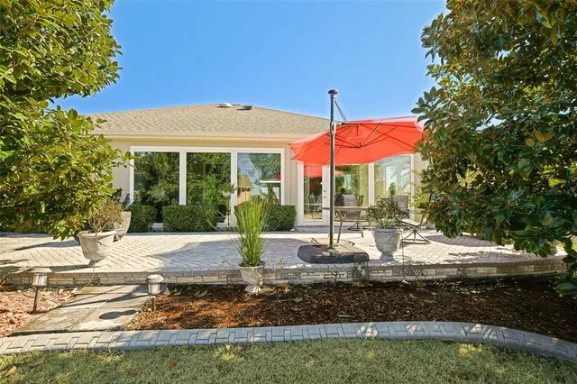 a view of a house with a yard and palm trees