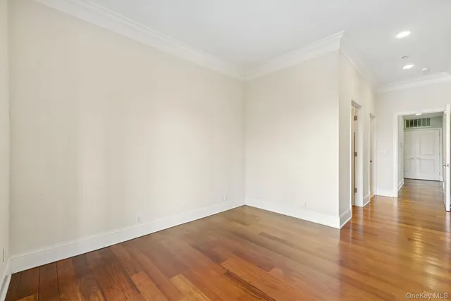 a view of a hallway with wooden floor and a living room