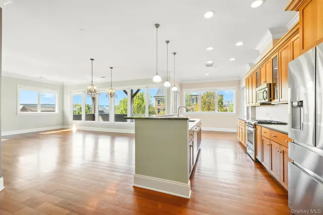 a kitchen with stainless steel appliances granite countertop a stove a sink and a wooden floors