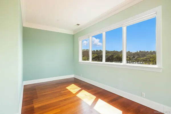 a view of a room with wooden floor and a window