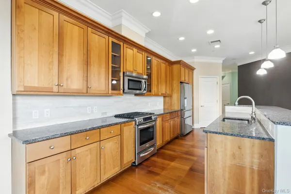 a kitchen with stainless steel appliances granite countertop a sink stove and refrigerator