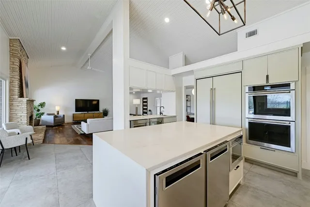 a kitchen with a stove a refrigerator and a couch