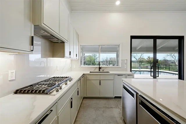 a kitchen with a sink stove top oven and cabinets