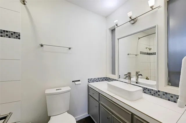 a bathroom with a sink toilet vanity and shower