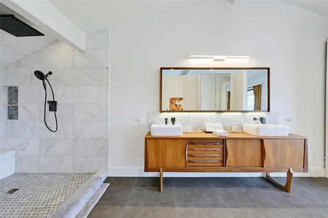 a bathroom with a sink a mirror and shower