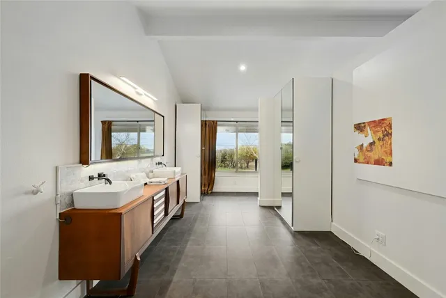 a spacious bathroom with a tub sink and mirror